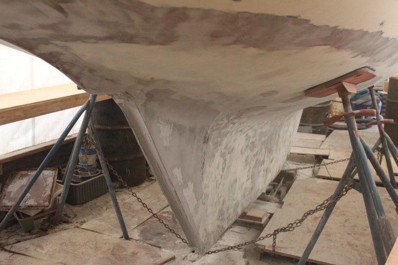 And one last shot of the bottom, again showing the aperture filled and rudder channel built into the trailing edge of the keel.  The waterline had a lot of pitting, so it was sanded down to fiberglass, and multiple layers of fairing have been applied.